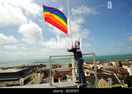 Ein Mann wirft die Regenbogenfahne auf die Royal Sussex County Hospital in Brighton zum Start der gay-Pride-Feierlichkeiten Stockfoto