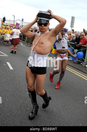 Zeichen, die Teilnahme an der diesjährigen Brighton Pride Prozession viele in Kostüm oder empörend outfits Stockfoto