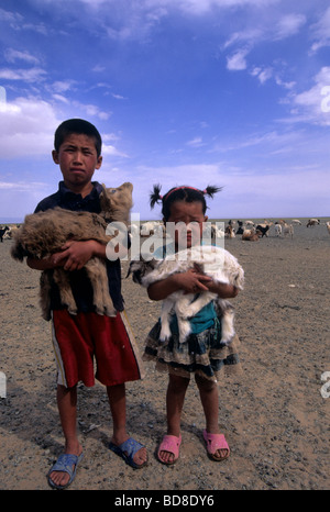 Mongolische Kinder halten ein Lamm in den Armen, Mongolei Stockfoto