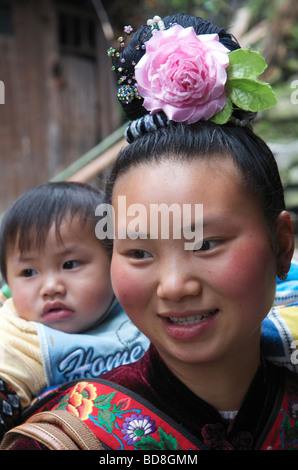 Nahaufnahme der Miao Frau mit Baby tragen Blume im Haar der Provinz Guizhou, China Stockfoto