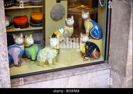 Keramik Katzen aus einem Schaufenster peering Stockfoto