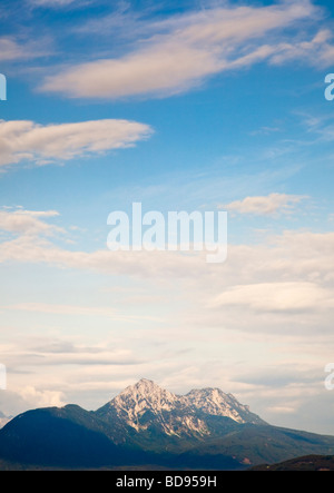 Berge mit Kopierraum - am frühen Morgen über einem Bergmassiv mit Kumulus und Lentikularwolken Stockfoto