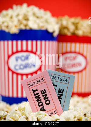 Zwei Popcorn-Eimer auf einem roten Hintergrund. Film-Stubs sitzen über das Popcorn. Stockfoto