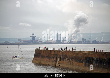 Angler, die von der Landzunge in Hartlepool mit Corus Stahlfabrik in Redcar im Hintergrund Stockfoto