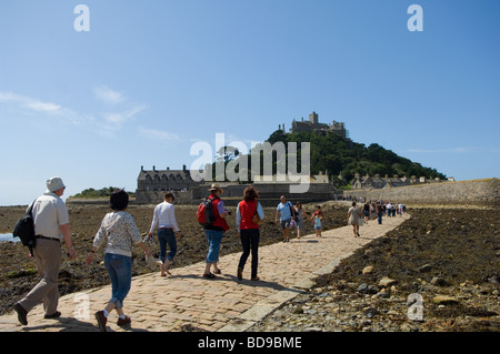 Touristen über den Damm bei Ebbe nach St Michaels Mount von Marazion auf dem kornischen Festland. Stockfoto