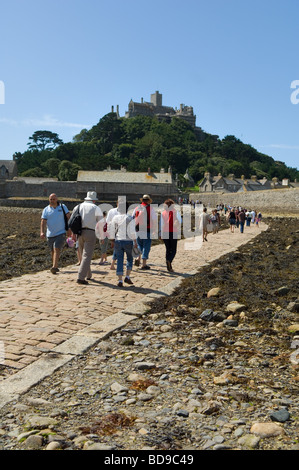 Touristen über den Damm bei Ebbe nach St Michaels Mount von Marazion auf dem kornischen Festland. Stockfoto