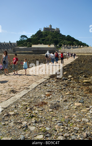 Touristen über den Damm bei Ebbe nach St Michaels Mount von Marazion auf dem kornischen Festland. Stockfoto