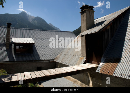 Steile Wellblechdächern und Gehweg in alpinen Dorf in der Nähe von Barcellonette, Alpes-de-Haute-Provence Frankreich Stockfoto