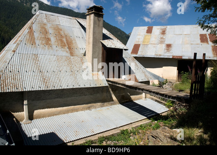 Steile Wellblechdächern und Gehweg in alpinen Dorf in der Nähe von Barcellonette, Alpes-de-Haute-Provence Frankreich Stockfoto