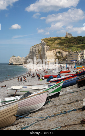 Fischerboote am Strand von Etretat mit der Kapelle von Notre Dame und Kalksteinfelsen in der Ferne, Normandie, Frankreich, Europa Stockfoto