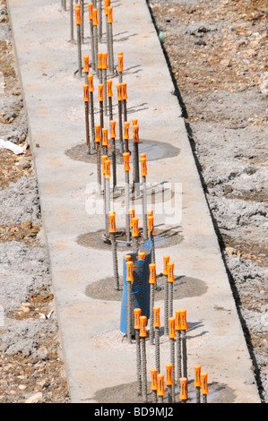 Leuchtend orange Schutzkappen ausgestattet, um die Enden der vorspringenden Stahl Bewehrungsstäbe auf Baustelle Stockfoto