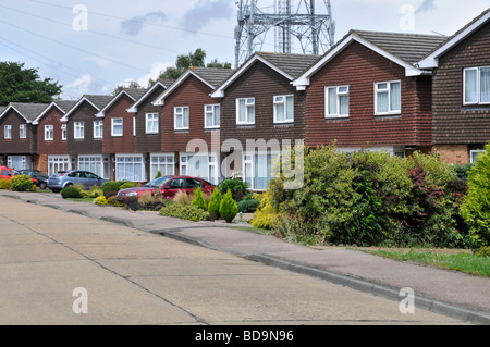 Reihe von Häusern in Wohnstraße von Immobilien-Gehäuse Grundstücksentwicklung identische Einfamilienhäuser individuelle Gärten & Auto Auffahrt England GB Stockfoto