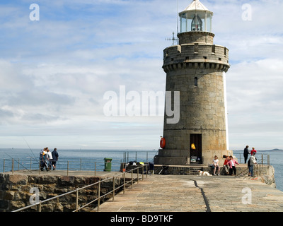 Angler und Touristen durch den Leuchtturm am Eingang zum St. Peter Port harbour Guernsey Kanalinseln Stockfoto