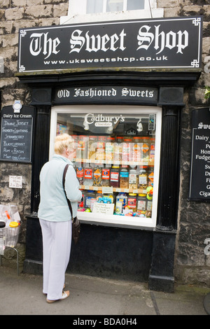 Frau Gläser von Süßigkeiten im Fenster eine altmodische Konditorei in Kirby Lonsdale Seenplatte Cumbria England betrachten Stockfoto