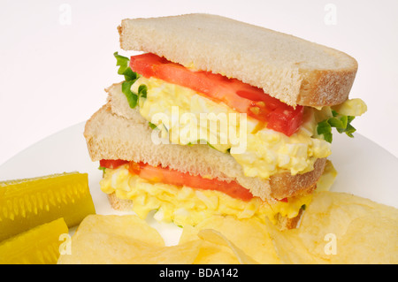 Eiersalat auf Weißbrot mit Salat Tomaten Gurken und Chips auf weißen Teller auf weißem Hintergrund. Stockfoto