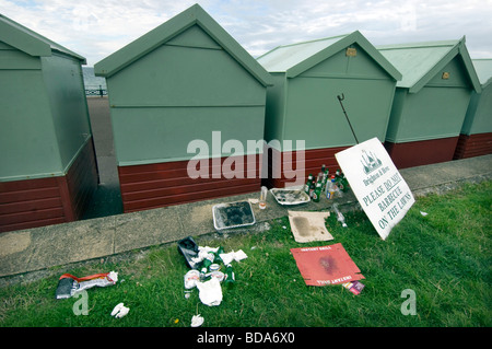 Chaos und Müll von Strandhütten auf Hove Rasen, neben einer Bekanntmachung, die Leute nicht zum Grillen auf dem Rasen zu Fragen. Stockfoto