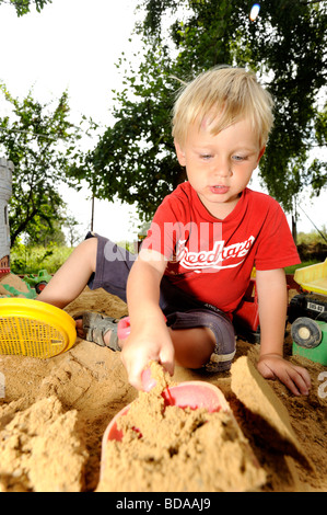Baby Kind junge Jungen in Sand Grube spielen mit Spaten und Spielzeug Auto Autos Fahrzeug Spielplatz 2-3-4 Jahre Stockfoto