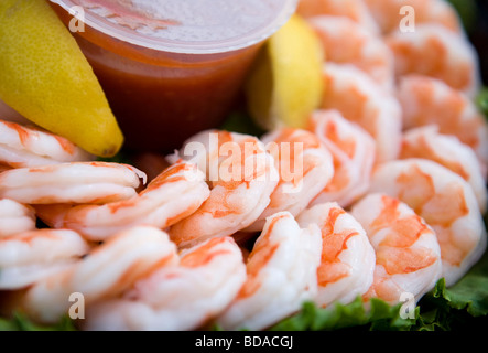 Gekochte Garnelen mit Zitronen und Salat auf einem Tablett. Stockfoto