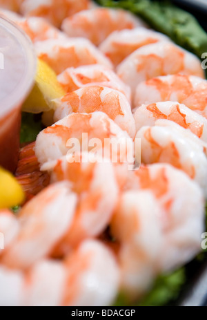 Gekochte Garnelen mit Zitronen und Salat auf einem Tablett. Stockfoto