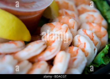 Gekochte Garnelen mit Zitronen und Salat auf einem Tablett. Stockfoto