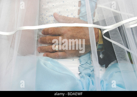 Eine Nahaufnahme der Hand des Vaters gelegt schützend um seine Tochter Taille vor einem traditionellen englischen kirchliche Trauung Stockfoto