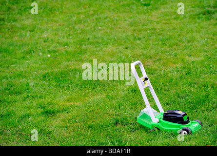 Kleines Kind 3 Jahre junge mähen den Rasen-Rasenmäher Stockfoto