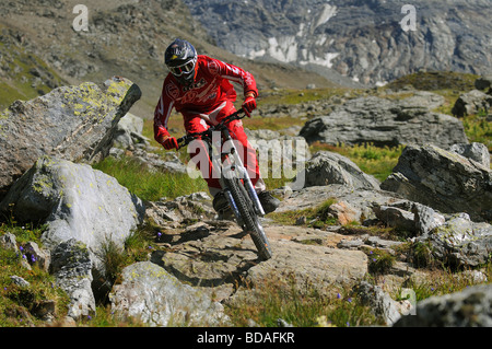 Ein downhill Mountainbiker reitet auf Felsen hoch in den Bergen oberhalb von Les Arcs in den französischen Alpen Stockfoto