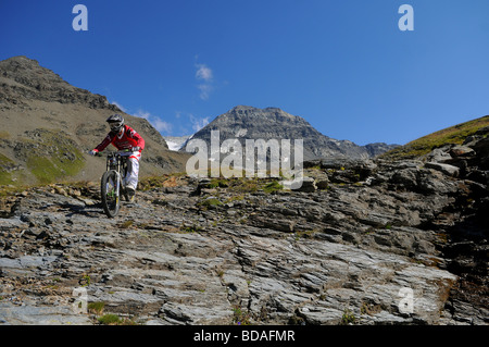 Ein downhill Mountainbiker reitet auf Felsen hoch in den Bergen oberhalb von Les Arcs in den französischen Alpen Stockfoto