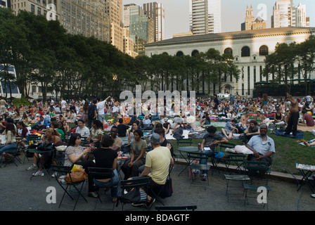 Tausende von Menschen ihre decken zu verbreiten und behaupten ihre Stühle im Bryant Park in New York am Montagabend kostenlosen Film Stockfoto