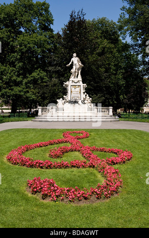 Mozart-Statue und Beetpflanzen in Form von einem Violinschlüssel auf gemähtem Rasen im Burggarten Wien Österreich Stockfoto