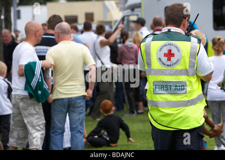 Mitglied des britischen Roten Kreuzes erste-Hilfe-Teams im Radio zu Fuß durch eine Menschenmenge bei einer Outdoor-Veranstaltung in belfast Stockfoto