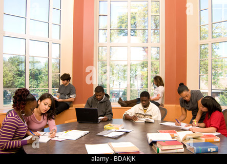 Ethnisch gemischten Gruppe von Studenten lesen und studieren in einer College-Bibliothek Stockfoto