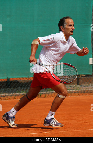 Älterer Mann spielt bei einem Tennisturnier Stockfoto