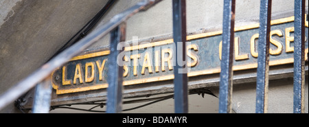 Eine Straße Zeichen aus Gusseisen, eingefasst in Gold zeigt "Lady Stair schließen" auf der Royal Mile in Edinburgh. Geländer sind im Vordergrund. Stockfoto