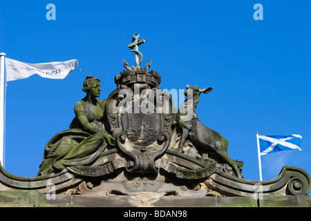 Der Flagge von Schottland und Edinburgh fliegen neben einem Steinrelief des Wappens von Edinburgh. Stockfoto