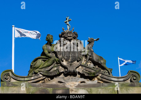 Der Flagge von Schottland und Edinburgh fliegen neben einem Steinrelief des Wappens von Edinburgh. Stockfoto