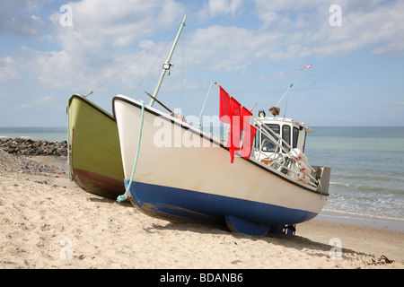 Dänische Fischerboote, die von einer Winde am Strand von Lønstrup, Loenstrup, an der nordwestlichen Küste von Jütland, Dänemark, gezogen werden. Rote Boje Flaggen. Stockfoto