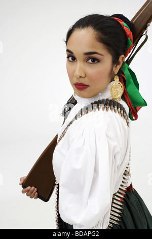 Porträt einer jungen Frau in typischen mexikanischen Tracht und hält eine Pistole Stockfoto