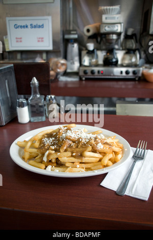 Ein Teller mit griechischem Poutine mit Feta-Käse, eine Art kultiges kanadisches Gericht, das in einem traditionellen Restaurant in Toronto, Ontario, Kanada, serviert wird. Stockfoto