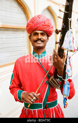 Mitte erwachsenen Mannes spielen Sarangi in einem Palast, Stadtschloss, Jaipur, Rajasthan, Indien Stockfoto