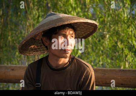 Portrait Mann raucht Zigarette und einen großen konischen Hut antiken Stadt Fenghuang Hunan China Stockfoto