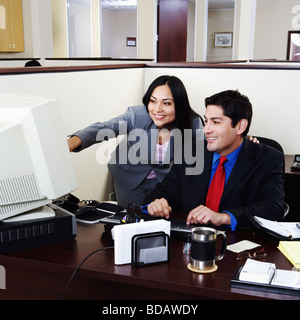 Geschäftsmann und eine Geschäftsfrau, die auf einem Desktop-PC in einem Büro arbeiten Stockfoto