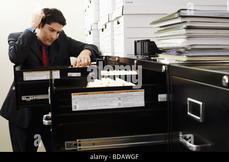 Dateisuche in einem Schrank Füllung Geschäftsmann Stockfoto
