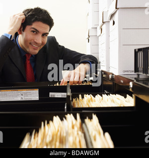 Porträt eines Geschäftsmannes Dateisuche in einem Schrank Füllung Stockfoto
