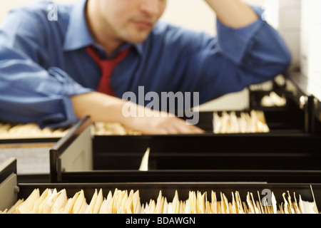 Dateisuche in einem Schrank Füllung Geschäftsmann Stockfoto