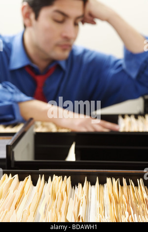 Dateisuche in einem Schrank Füllung Geschäftsmann Stockfoto