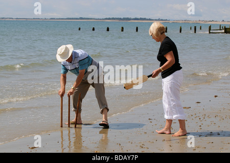 Frau spielt Cricket am Meer im Ruhestand genießen gesunden Bewegung am Strand Stockfoto