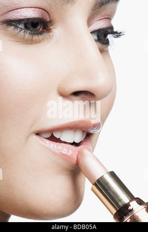 Nahaufnahme einer jungen Frau Auftragen von Lippenstift auf den Lippen Stockfoto