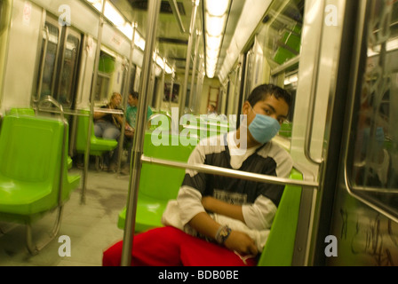 Ein junger Mann trägt einen Mundschutz in der u-Bahn von Mexiko-Stadt während eines Ausbruchs der Schweinegrippe. Stockfoto