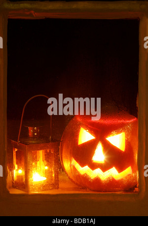 Eine geschnitzte Halloween-Kürbis und eine Laterne in einem Fenster Stockfoto